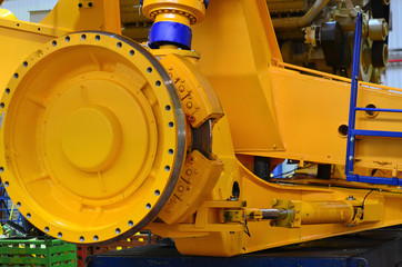 Close-up view of the detail of a large mining truck in the production workshop of the plant. Huge brake disc. Wheel. Truck electric motor