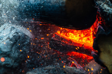 Smoldered logs burned in vivid fire close up. Atmospheric background with flame of campfire....