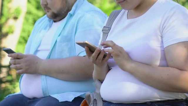 Two young people using smartphones in park, problems with live communication