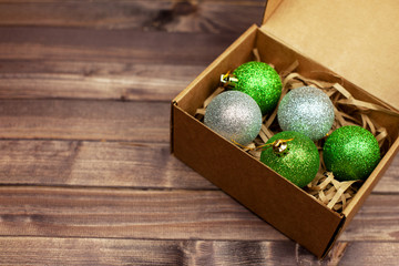 Colorful Christmas balls in a box on a wooden table