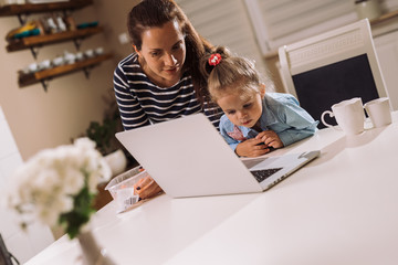 New age is digital age. mother and daughter using laptop