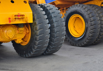 Tires with rims and electric motor-wheels engines of a yellow career dump trucks, mining trucks.