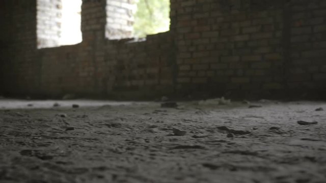 Close-up of army soldiers legs in old paratrooper boots running through dusty ruined building during military operation. Squad fully equipped and armed soldiers running forward and attacking enemy.