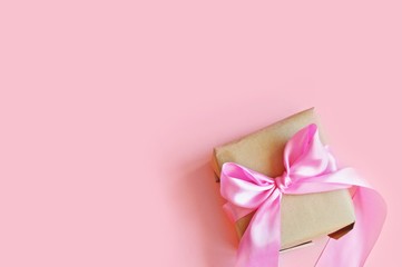 Wrapped gift box and photo tied with a satin pink ribbon on top. Free space for text. Flat lay photo