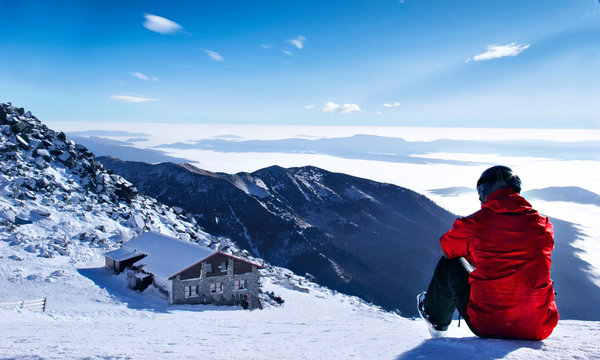 Winter lanscape mountains.Skier siting on the snow on the first plan and mountain house on the second plan.Chopok, Slovakia
