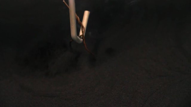 Heated metal goes into a container of teflon powder coating to apply a fresh new coat