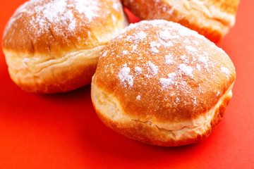 Tasty sweet donuts with powdered sugar on bright red background