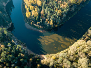 drone image. aerial view of wavy river in autumn colored forest