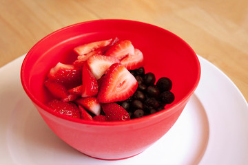 strawberries in bowl on wooden table