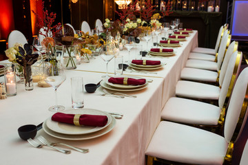 a decorated table decorated with flowers and cloth napkins on plates in the interior of the restaurant