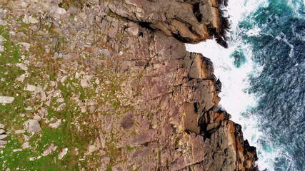 Deep blue ocean water and steep cliffs from above