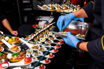 gloved hands putting food at the banquet