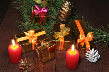 Christmas gift gold, red box with gold color bow and candles. Christmas decoration.