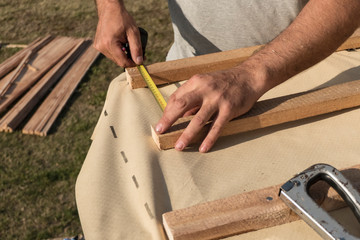 Roof construction building. Man measuring elements with tape measure or scoop.