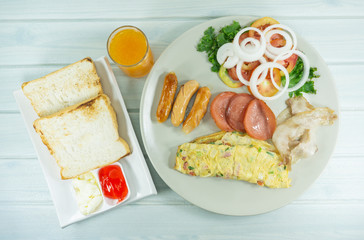 Breakfast omelette butter and orange juice in plate on a white wood floor table, Top view, Copy space.