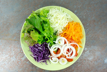 Green salad eat healthy ,Onion and green Salad in green Plate on stone floor background, front view, with copy space for your text.