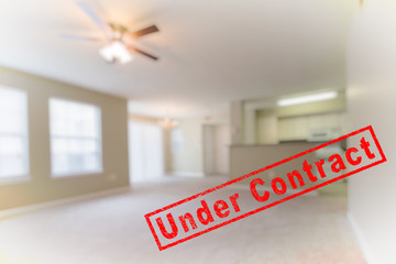 BLUR IMAGE OF CLEAN AND BRIGHT ROOM WITH NATURAL LIGHT FROM WINDOWS AND RED " Under Contract " RUBBER STAMP