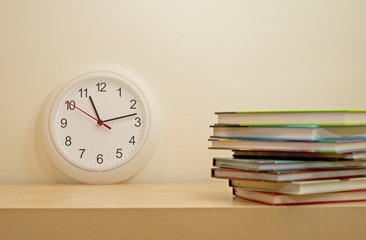 STACK OF TEXT BOOKS AND CLOCK SHOWING ALMOST MIDNIGHT