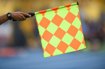 Assistant referee hold flag , offside signal.