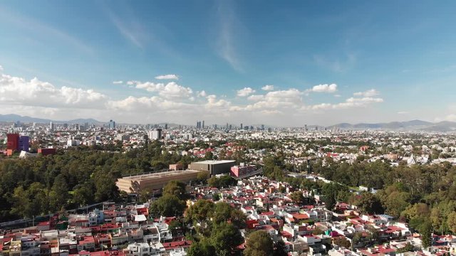 Aerial panoramic view of the skyline in Mexico City on a very clear day with blue sky and lots of clouds. Drone flying backwards