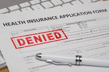 Fototapeta premium HEALTH INSURANCE APPLICATION FORM WITH RED DENIED RUBBER STAMP AND WHITE PEN