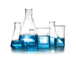 Laboratory glassware with liquid on table against white background. Chemical analysis