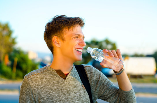 Happy teenager , healthy lifestyle drinking water from bottle outdoors, closeup portrait  