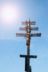 OLD WOODEN POLE ELECTRIC TRANSMISSION LINE / POWER SUPPLY.WITH SUN AND LENS FLARE