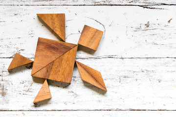 Tangram puzzle in turtle shape on old white wood background