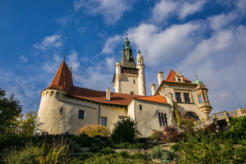 Famous romantic Pruhonice castle, Czech Republic, Europe, standing on hill in a park, sunny fall day, blue sky, white clouds, green foreground, bright colors