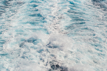 abstract and background of water stream after ship in blue sea