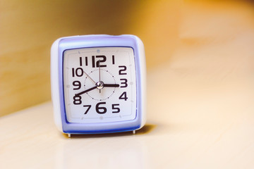 Blue and white square analog clock. Space for text.
