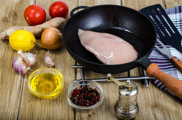 Raw chicken fillet in frying pan, spices