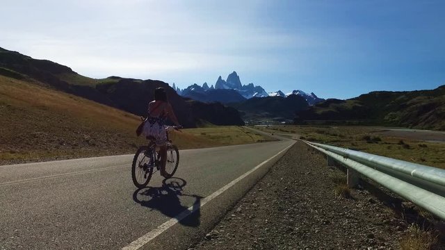 Footage of woman biking towards Mt. Fitz Roy, mountains of Patagonia Argentina