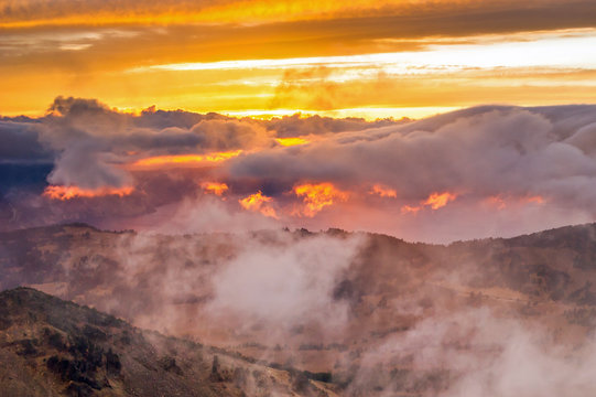 Crater Lake National Park.  Sunset lights up the clouds as seen from Mt Scott.