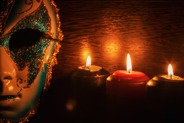 masquerade mask and candles on a black background