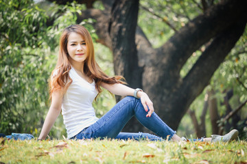 Portrait Asian woman wearing a T-shirt and jeans. Are happy in the public park