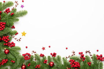 Christmas and New Year's composition. Top view of spruce branches, pine cones, red berries and bell on white background.