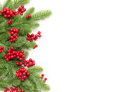Christmas and New Year's composition. Top view of spruce branches and red berries on white background.