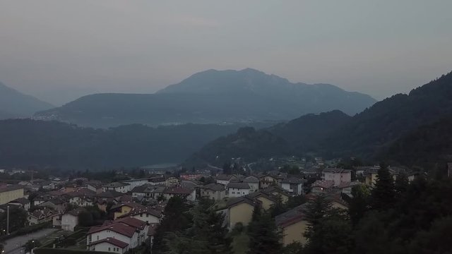 Aerial panoramic view of Levico Terme, Italy, during sunrise with drone flying sideways