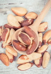 Vintage photo, Heap of brazil nuts with wooden spoon on rustic board