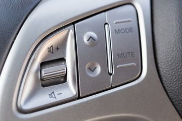 Closeup of Audio Control Buttons on the Steering Wheel of Car