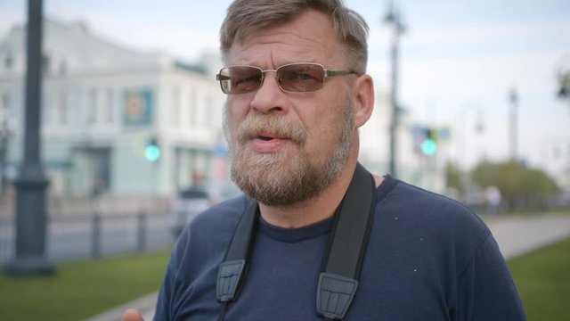 Man smoking a cigarette on a street. Close-up.