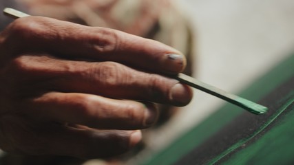 Artist painting on canvas with green colors