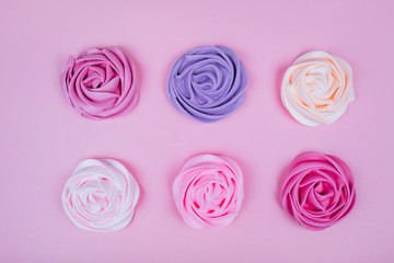 Beautiful pink, magenta, orange and violet rose flower shaped meringue flatlay.