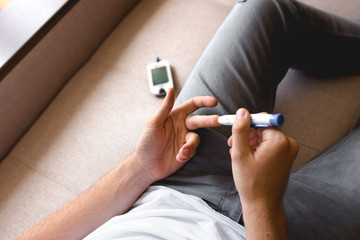 Handsome stylish young teen caucasian white brunette guy man european taking a blood sample with a...