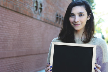 Woman holding chalkboard.