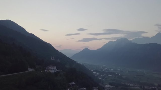 Aerial view of Levico Terme, Italy during sunrise with drone flying forward