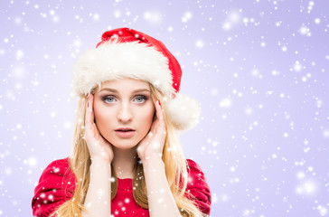 Beautiful, young and pretty girl in Christmas hat over background with snow. 