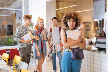 Afraid them. Positive delighted pupils laughing at joke while looking at their classmate